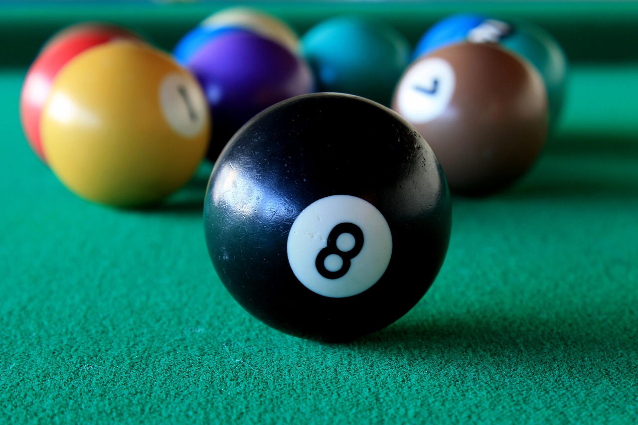 Black 8-ball on a green pool table with colorful billiard balls